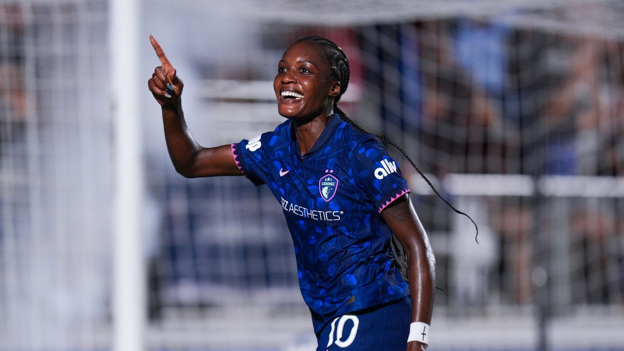 Эвелина Идже празднует это событие в синей рубашке North Carolina Courage