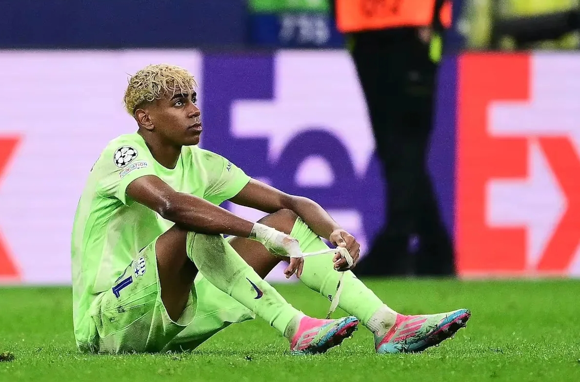 Игрок "Барселоны", сидящий на поле с усталым видом